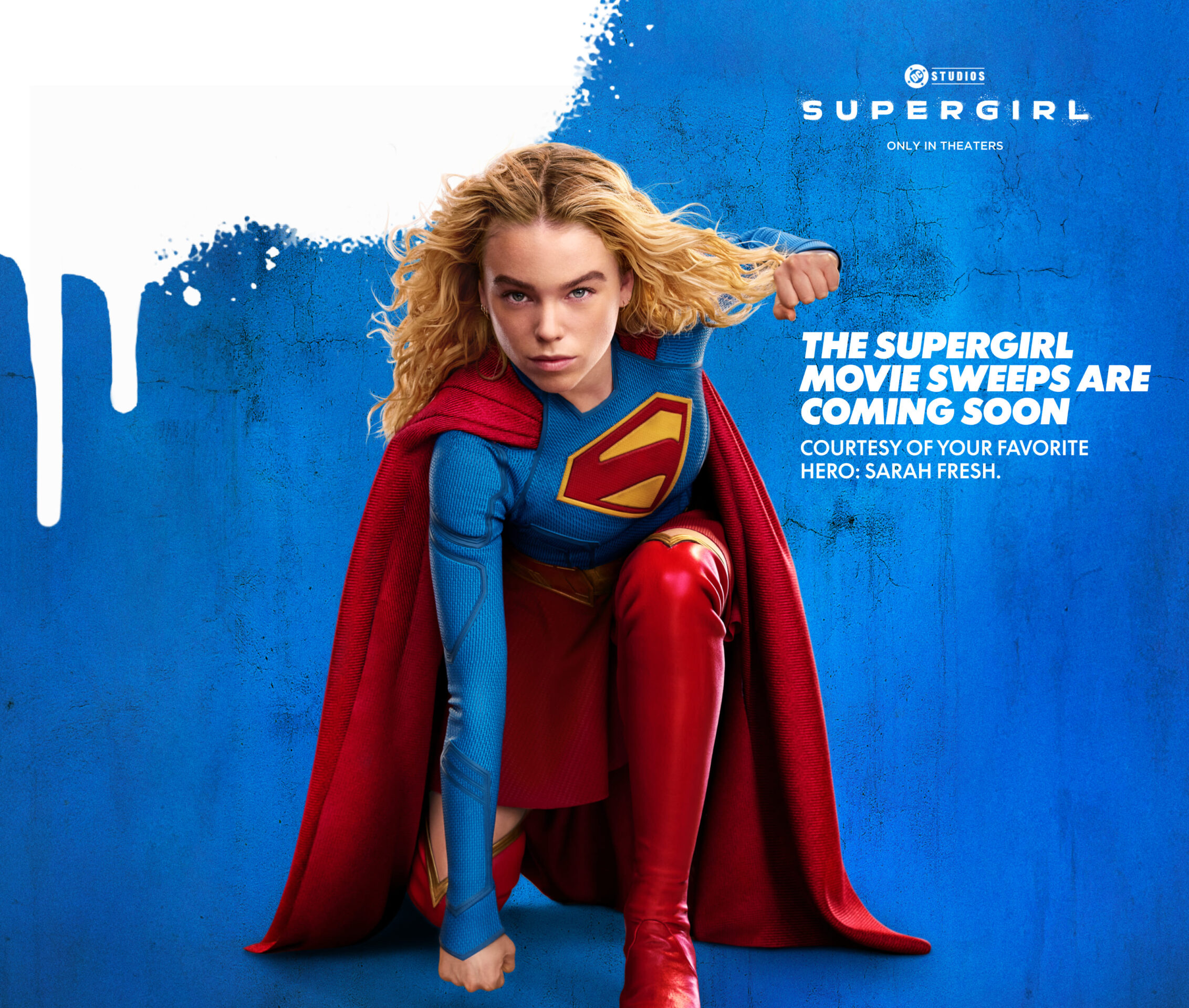 Supergirl crouches on the ground with her left hand curled into a fist.